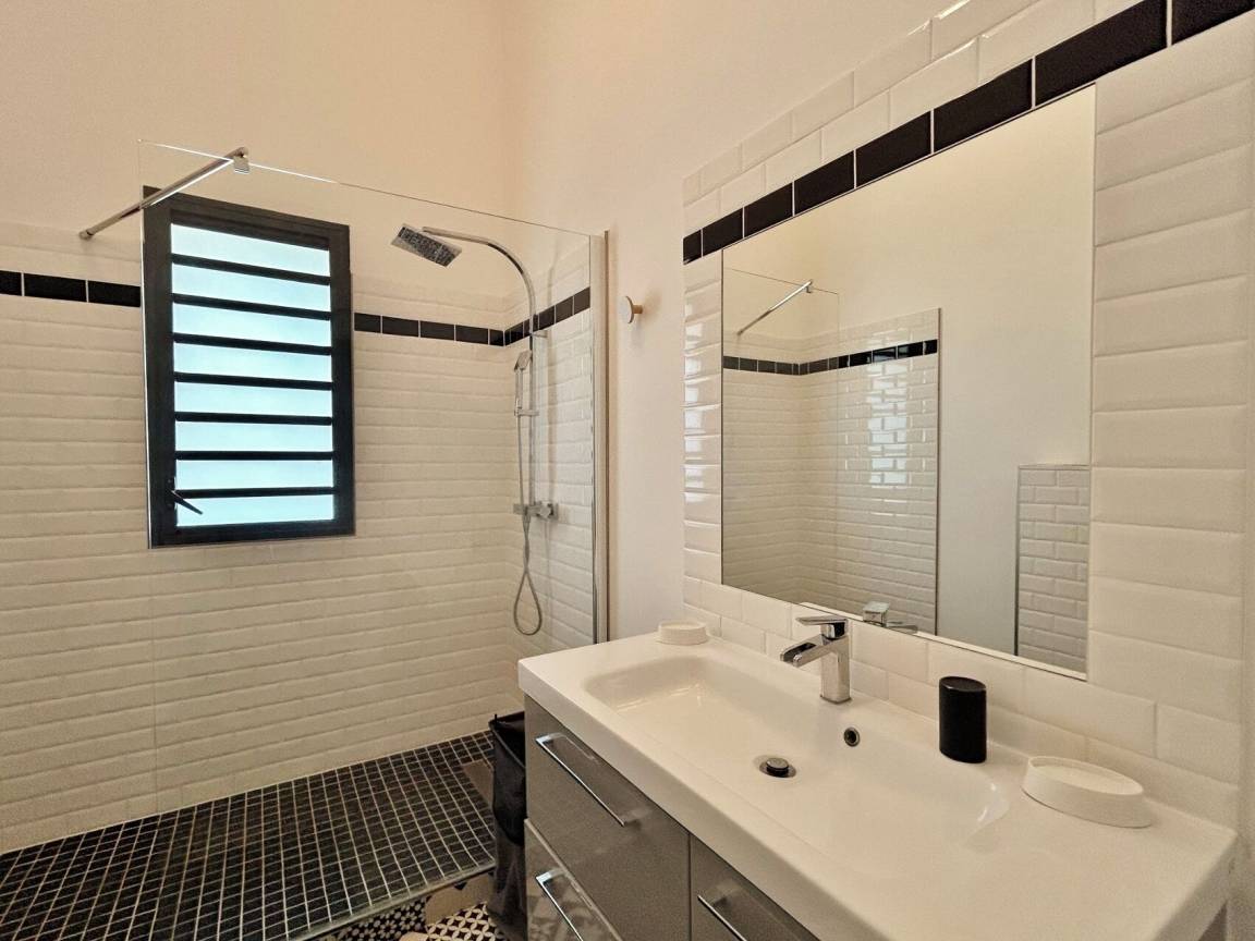 Salle de bains avec douche et grand miroir